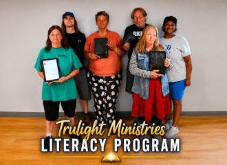 Trulight Ministries Literacy Program students and staff holding tablets during the launch of the faith-based adult literacy program in Zanesville, Ohio.